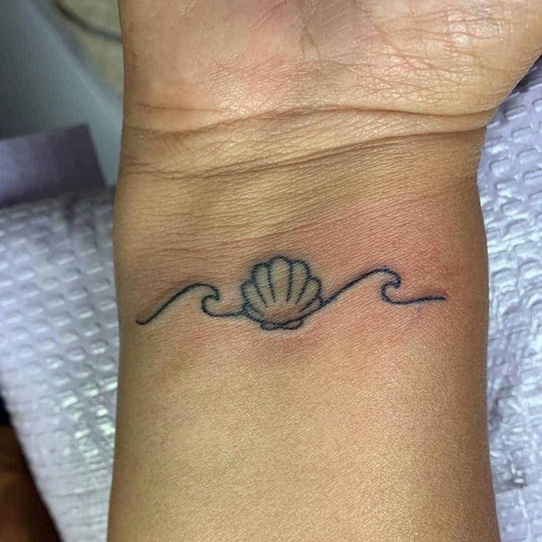 A Seashell and Waves Line Tattoo